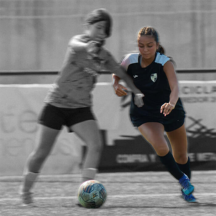 Bre Mendez fights for control of the ball against an opponent in a midfield clash during a soccer match.